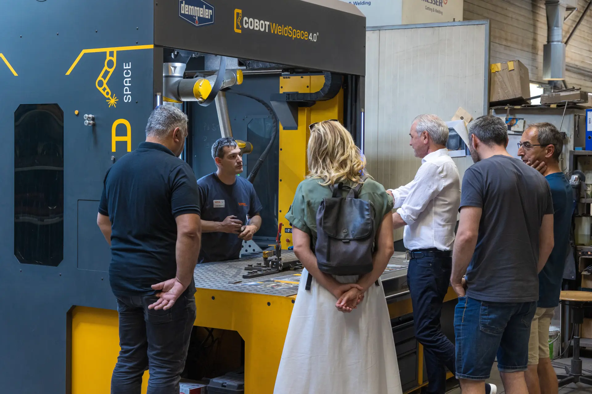 Besucher im Gespräch am Schweißroboter WeldSpace 4.0